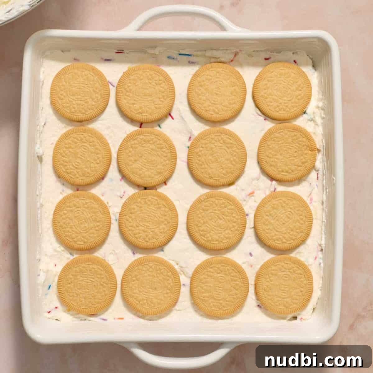 No-Bake Funfetti Icebox Cake Recipe with Whipped Frosting 12 4 by 4 Golden Oreos arranged in pan.