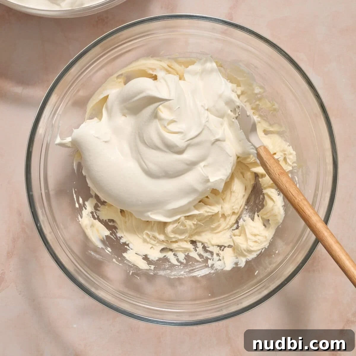 No-Bake Funfetti Icebox Cake Recipe with Whipped Frosting 6 Cool whip added to cream cheese mixture in mixing bowl.