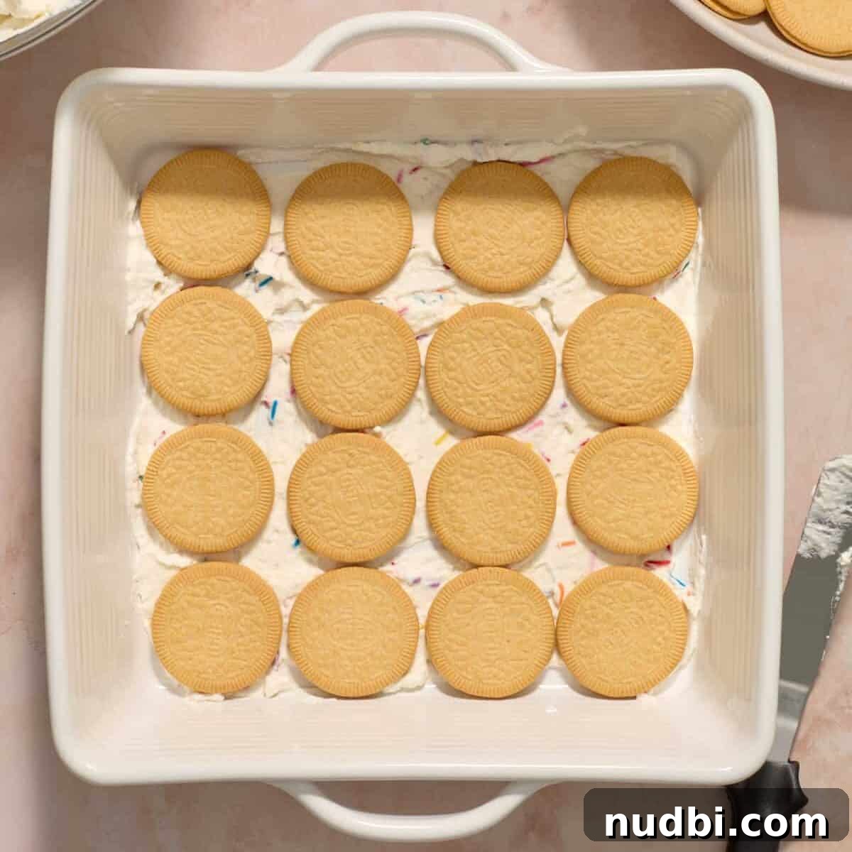 No-Bake Funfetti Icebox Cake Recipe with Whipped Frosting 10 White baking pan with Golden Oreo thins arranged 4x4.