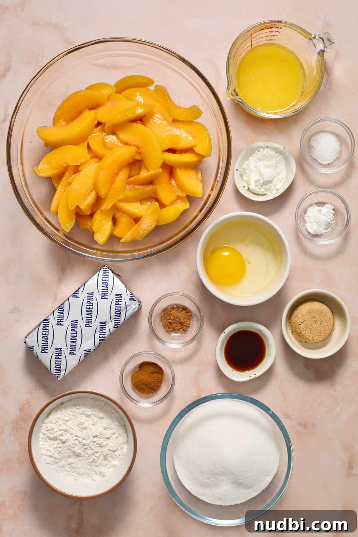 Cream Cheese Peach Cobbler with Buttery Biscuit Topping 4 Cream cheese, sliced peaches, sugars, egg and other ingredients on surface.