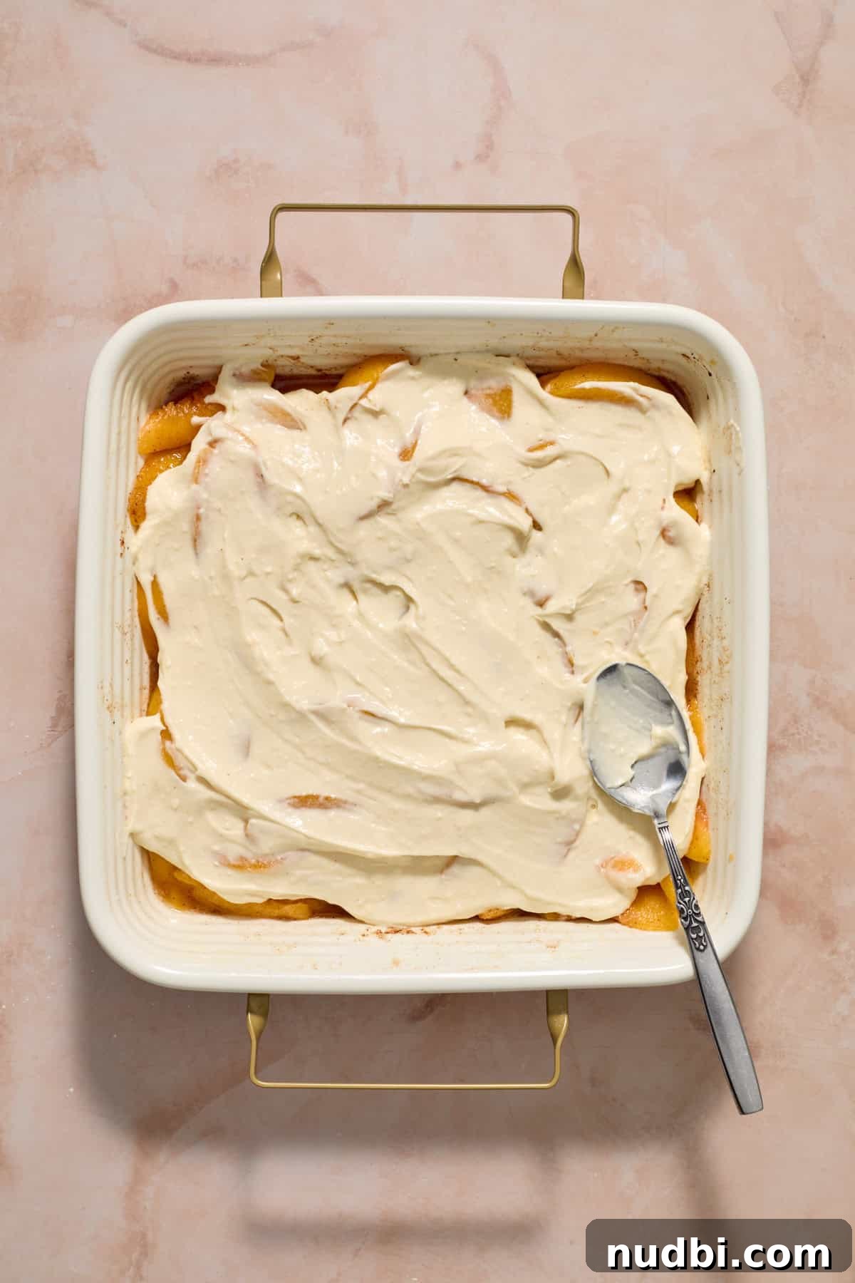 Cream Cheese Peach Cobbler with Buttery Biscuit Topping 7 Cheesecake mixture spread over peaches.