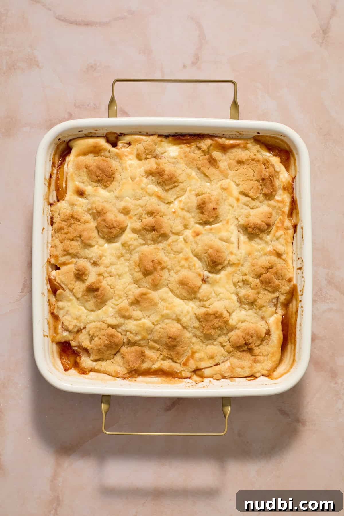 Cream Cheese Peach Cobbler with Buttery Biscuit Topping 10 Baked cream cheese peach cobbler in pan.