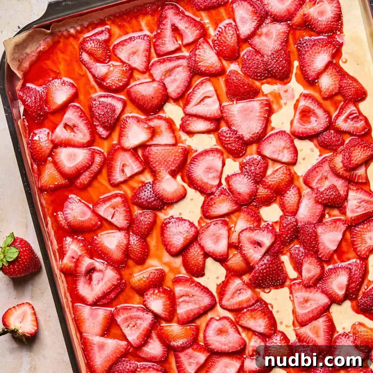Roasted strawberries on parchment lined baking pan.