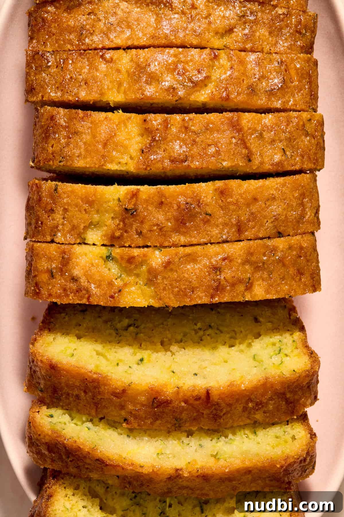 Slices of lemon glazed loaf of lemon zucchini bread.