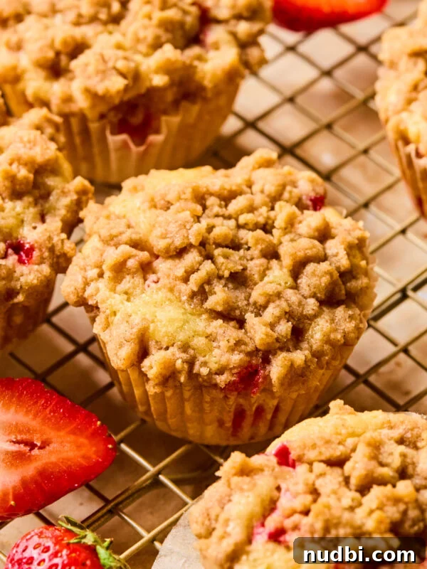 Strawberry muffins with crumb topping on wire rack.