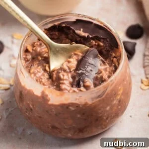 Chocolate overnight oats in jar with spoon.
